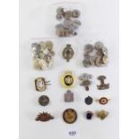 A selection of brass military buttons and cap badges, enamel badges etc.