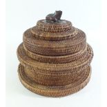 A vintage woven snake basket with carved wooden frogs head finial