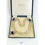 A cased set of Pompadour simulated pearls with interchangeable coloured paste set clasps