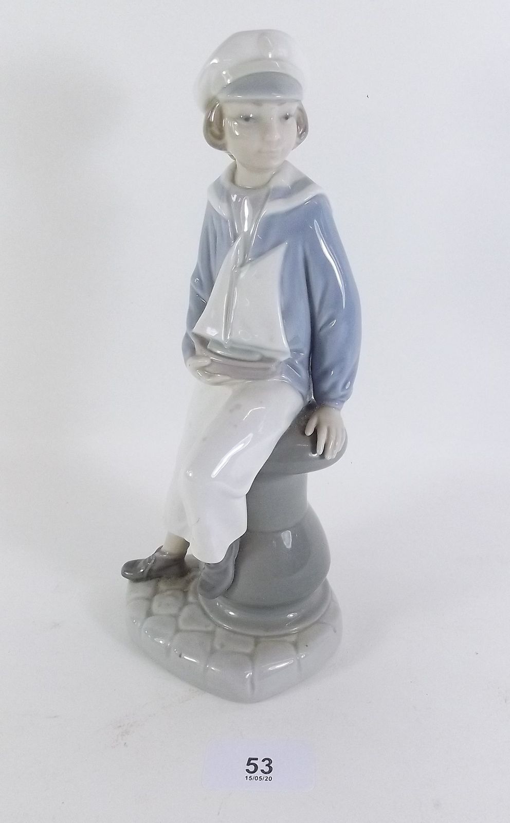 A Lladro figure boy with yacht