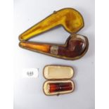 An amber and silver mounted pipe and a yellow metal mounted cheroot holder - both cased
