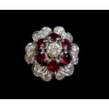 An 18 carat gold ruby and diamond cluster ring - size K