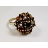 A 9 carat gold ring set garnets and seed pearls, size O 1/2