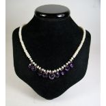 A pearl necklace suspended amethyst drops