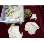 A box of assorted textiles and accessories including wedding veils, lace babies bonnets etc