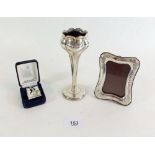 A silver Art Nouveau vase - 14cm, a silver photograph frame 10 x 7.5 cm and a silver napkin clip