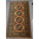 A Turkoman style rug with four guls on a mustard ground 152 x 86cm
