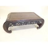 A Chinese carved hardwood low coffee table on inward curved supports