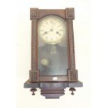 A 19th century continental wall clock with carved decoration and musical movement