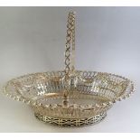 A George III silver cake basket with all over pierced and embossed decoration and swing handle,