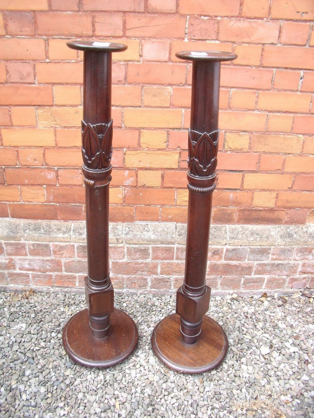 A pair of mahogany torchere stands with carved decoration - 121cm tall