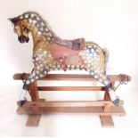 An early 20th century Collinsons full size dapple grey rocking horse on twin pillar safety stand,