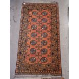 A Turkoman style rug with two rows of seven guls on an orange ground 151 x 80cm