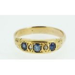 A gold ring set three sapphires and two chip diamonds, size N