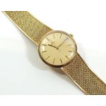A 9 carat gold Omega gentleman's wrist watch with date niche and integral strap, total weight 59g