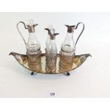 An early 19th century silver plated cruet stand on four claw and ball feet fitted four cut glass and