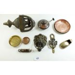 A box of small metal and brass items to include door knockers, oil burner etc.