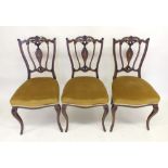 A set of three Edwardian mahogany side chairs with marquetry decoration to backs