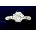 A fine 18 ct white gold ring set large central diamond (approx 1 carat) on baguette cut diamond