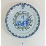 A 19th century continental Faience plate painted portrait of a Queen within floral and foliate