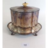 A silver plated biscuit box with engraved classical decoration, ivory finial and four claw feet