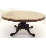 A Victorian walnut oval breakfast table on carved column and quadruple carved scroll supports