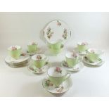 A Royal Albert tea service in apple green and painted blossom to interior compiling of 7 cups, 6