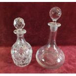 A cut glass decanter and a clear glass decanter