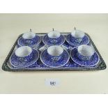 A Persian small enamel set of six cups and saucers on a tray decorated flowers and birds