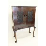 A Chinese hardwood cabinet with carved decoration to doors all raised on slender supports, width