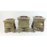 An unusual set of three Japanese stoneware square green planters on folded feet, tallest 18cm