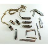 A tin of whistles and penknives to include military and Acme Thunderer etc.