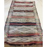A large antique woven tribal rug with geometric motifs - 279 x 153cm