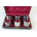 A set of six silver plated napkin rings, cased