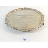 A silver salver with presentation engraving on three scroll feet, 512g, 25cm diameter