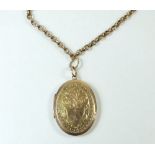 A 15 carat gold front and back oval engraved locket and a gold plated fob chain
