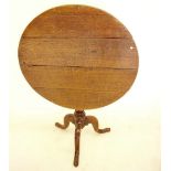 A 19th century oak tilt top circular wine table on turned column and triple curved supports