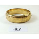 A gold plated bangle with engraved decoration