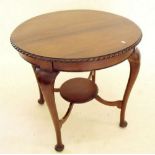 An early 20th century mahogany circular coffee table with undertier