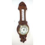 An aneroid barometer in carved oak case