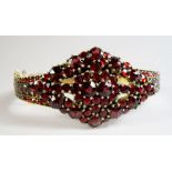 A Victorian hinged bangle set garnets (over 250) to lozenge design front and fully around the band -