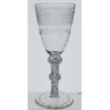 An 18th century large wine glass with all over engraved decoration to bowl and foot and with
