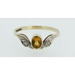 A 9 carat gold ring set yellow topaz and chip diamonds, size N