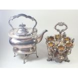 A silver plated eggcup stand and a silver plated kettle on a stand