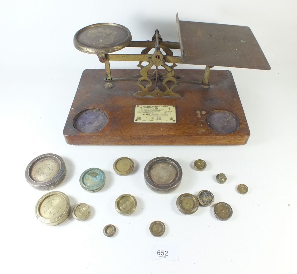 A set of oak postal weighing scales with weights
