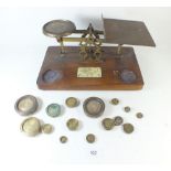 A set of oak postal weighing scales with weights