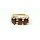 A 9 carat gold three stone garnet ring, size M