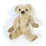 A small blonde Farnell teddy bear with glass eyes, stitched nose and mouth & fabric paws, 26cm