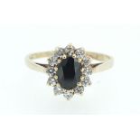 A 9 carat gold sapphire and white stone cluster ring - size N 1/2.