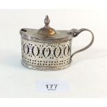 A silver oval cruet with pierced and engraved decoration, hinged lid and blue glass liner